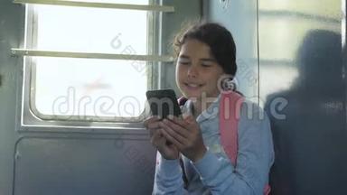 年轻的女孩旅行者带着一个背包，坐在装有智能手机的车窗上的背包上。 <strong>旅游线路</strong>